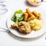 Op tafel staat een bord klaar met een gebraden kippenbout, goudgele appelmoes en kroketten. We serveren deze klassieker met nog wat extra sla en ev nog wat appelmoees. 