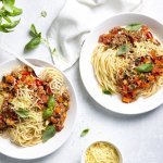 Twee borden gevuld met huisgemaakte spaghetti bolognaise. Afgewerkt met basilicumblaadjes die zorgen voor extra smaak en kleur in je bord. 