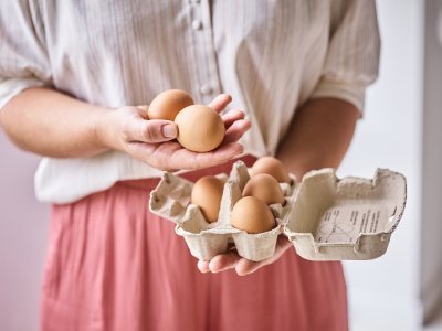 Vrouw houdt een doosje eieren vast