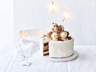 Een prachtige laagjestaart opgebouwd uit chocolade biscuit, vanille-ijs, karamelijs en chocolade-ijs. De taart kreeg een witte afwerkingslaag aan de buitenkant en aan de bovenzijde liggen verschillende bollen ijs. Als afsluiter werden er sterrenstokjes aangestoken bovenop de taart.  