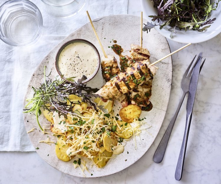 Er staat al een porseleine schotel op tafel, een ei-vormige schaal. Gevuld met de brochettes van kalf, gebakken aardappelen en een potje met de truffelmayonaise.