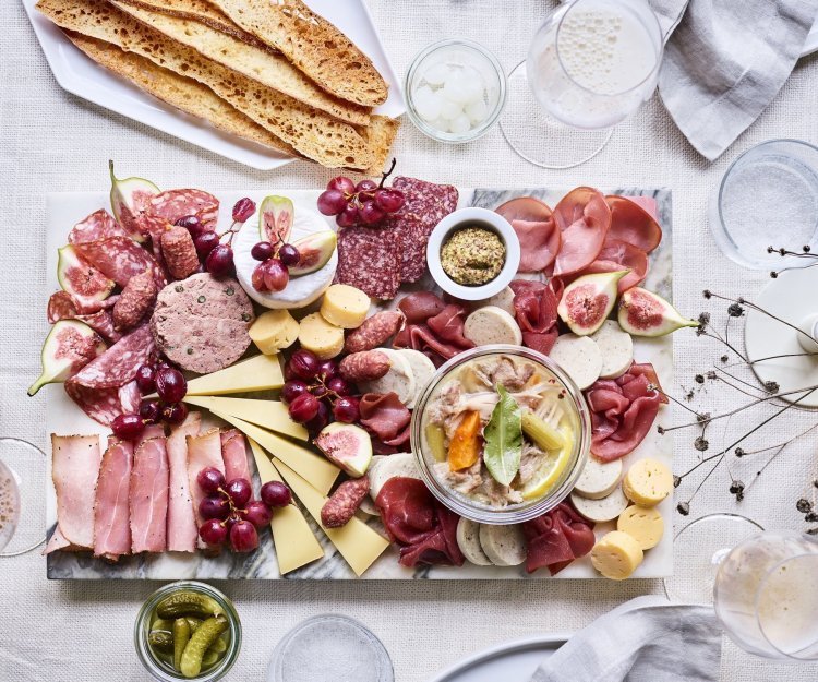 Op het midden van de tafel staat een grote schaal van natuursteen. Je kan deze schotel zien als een grote tapasschotel, maar dan boordevol Belgisch lekkers. Denk maar aan charcutterie, kazen, mosterd en toast. 