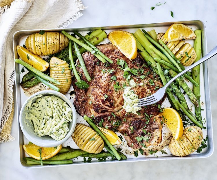 Een grote bakplaat gevuld met lekkers van bij ons, denk maar aan een mooi stukje vlees, groene asperges, boontjes, hasselback aardappelen en knoflookboter. 