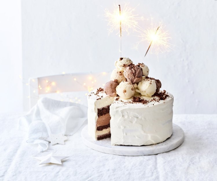 Een prachtige laagjestaart opgebouwd uit chocolade biscuit, vanille-ijs, karamelijs en chocolade-ijs. De taart kreeg een witte afwerkingslaag aan de buitenkant en aan de bovenzijde liggen verschillende bollen ijs. Als afsluiter werden er sterrenstokjes aangestoken bovenop de taart.  