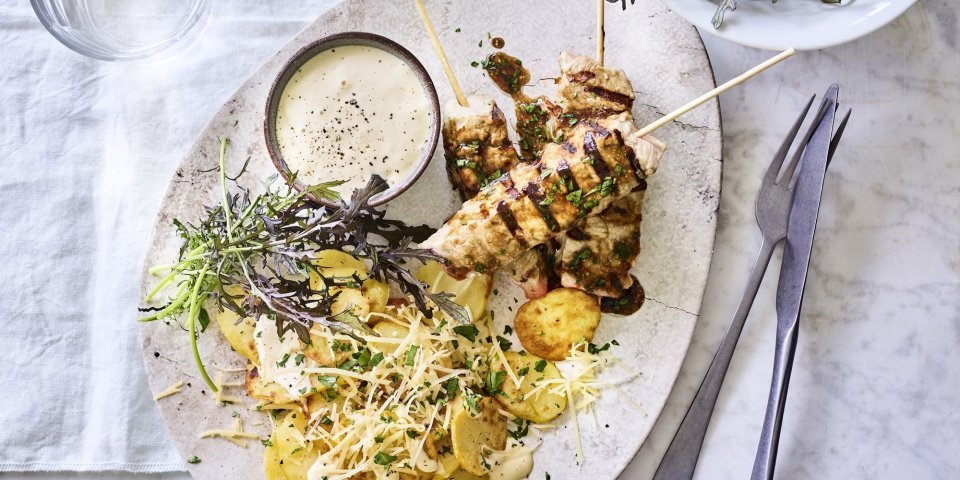 Er staat al een porseleine schotel op tafel, een ei-vormige schaal. Gevuld met de brochettes van kalf, gebakken aardappelen en een potje met de truffelmayonaise.