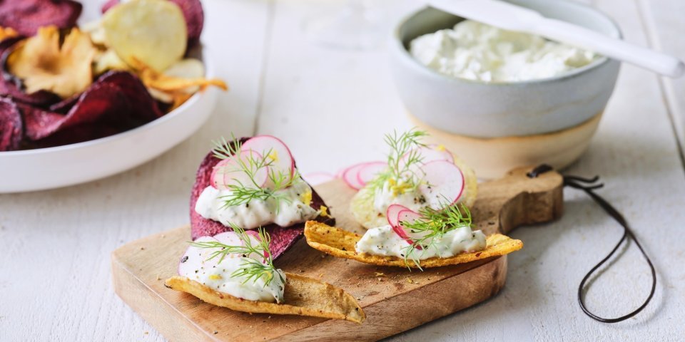 Een hapje van chips? Yes, please. Wij maakten een heerlijke topping op een chipke, eentje van roomkaas afgewerkt met schijfjes radijs en dille. 