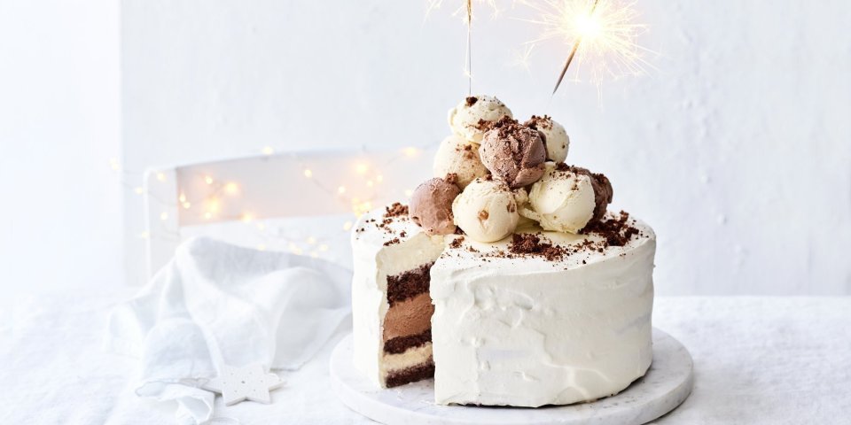 Een prachtige laagjestaart opgebouwd uit chocolade biscuit, vanille-ijs, karamelijs en chocolade-ijs. De taart kreeg een witte afwerkingslaag aan de buitenkant en aan de bovenzijde liggen verschillende bollen ijs. Als afsluiter werden er sterrenstokjes aangestoken bovenop de taart.  