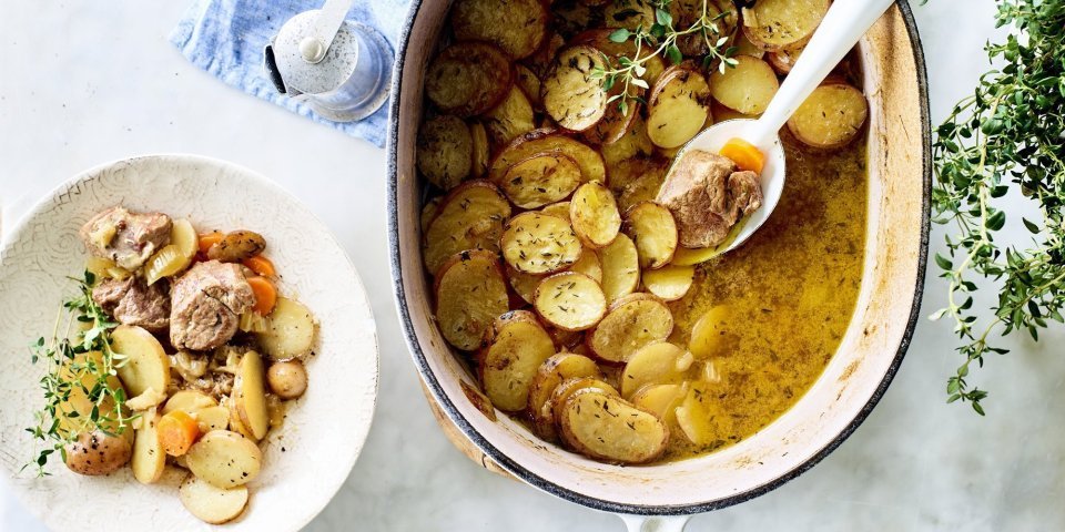 Stoofpotje met lamsvlees staat klaar op tafel om uit geschept te worden. Bovenop de stoofpot ligt een laagje krokante aardappelschijfjes. Deze stoofpot noemt men Lancashire hotpot. 