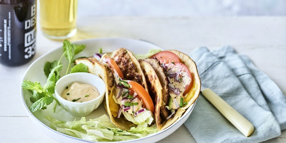 Een twee gevouwen tortilla met hamburger en kaas, die wil ik wel proberen. We werkten hem af met plakjes tomaat, blaadjes ijsbergsla en een homemade sausje. We serveren hem met een fris pintje en nog wat extra sla. 