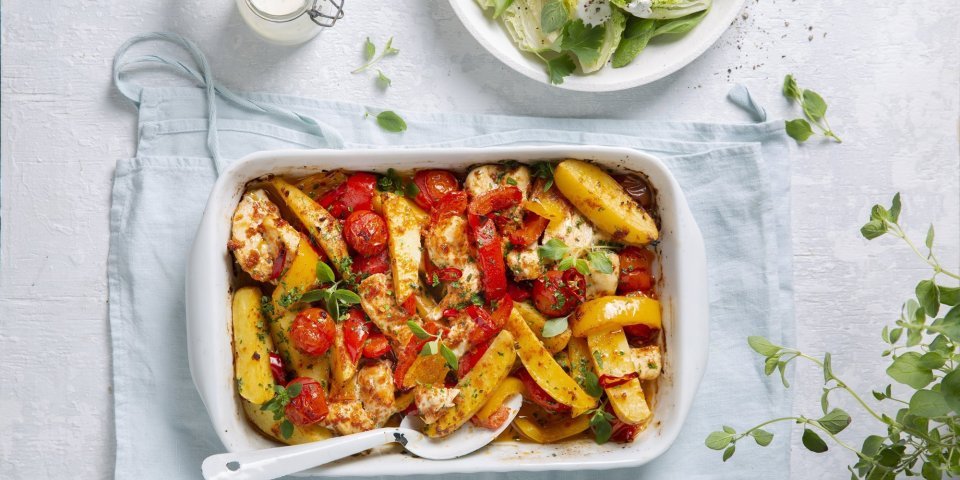 Een heerlijke hoofdmaaltijd in één ovenschaal met stukjes aardappel, tomaten, paprika en kip. Er is ook een knapperige salade van little gem met yoghurtdressing.