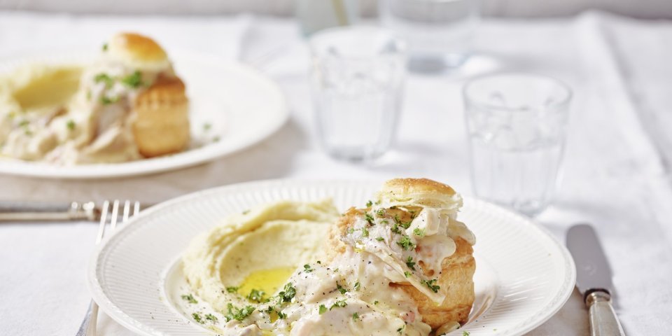 De tafel met wit linnen is gedekt voor twee. We eten een vol-au-vent van konijn ipv kip. Hij is opgediend met een bladerdeegpasteitje en aardappelpuree. 