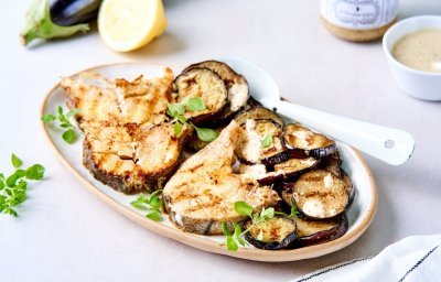 Een groot ovaal bord staat op tafel met de gebakken vismoten erop, samen met de gebakken aubergineschijfjes. De mosterpot van Tierenteyn staat er langs, samen met het gemaakt mosterdsausje. Het gerechtje werd afgewerkt met verse oreganoblaadjes. 