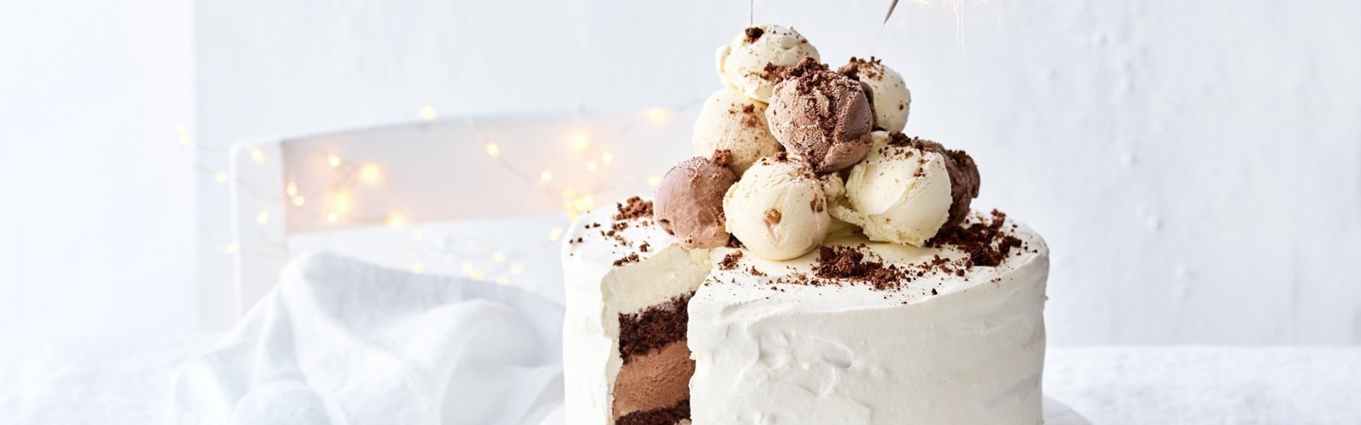 Een prachtige laagjestaart opgebouwd uit chocolade biscuit, vanille-ijs, karamelijs en chocolade-ijs. De taart kreeg een witte afwerkingslaag aan de buitenkant en aan de bovenzijde liggen verschillende bollen ijs. Als afsluiter werden er sterrenstokjes aangestoken bovenop de taart.  