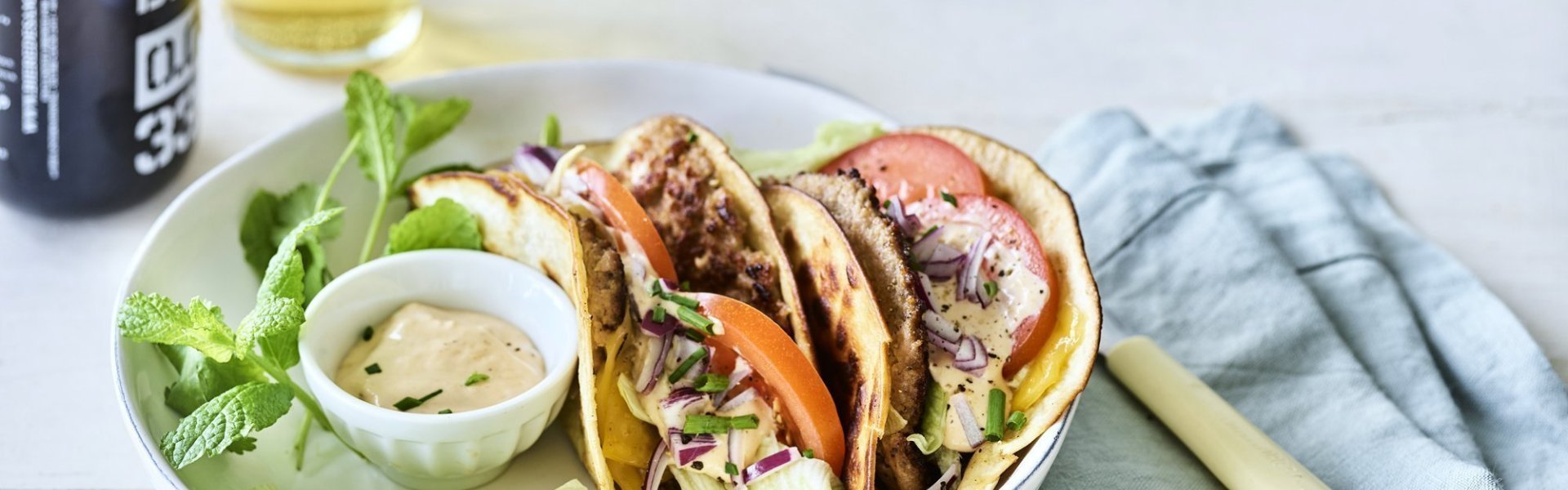 Een twee gevouwen tortilla met hamburger en kaas, die wil ik wel proberen. We werkten hem af met plakjes tomaat, blaadjes ijsbergsla en een homemade sausje. We serveren hem met een fris pintje en nog wat extra sla. 